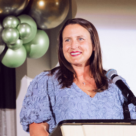 Rachel Freeman behind a podium at a speaking event
